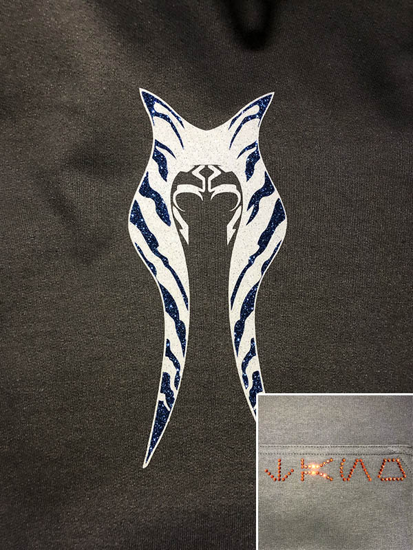 alien headdress design in white and blue glitter and alien type in orange rhinestones on a dark gray hoodie