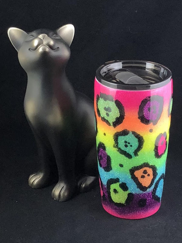 cup decorated in a neon rainbow design with neon leopard spots